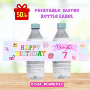 Könnte beinhalten: Zwei durchsichtige Plastikwasserflaschen mit einem bedruckbaren Etikett auf pastellfarbenem Karohintergrund. Das Etikett zeigt den Text "HAPPY BIRTHDAY", "Brigitte" und die Zahl "7", verziert mit Symbolen von Kirschen, Smileys und Blumen.
