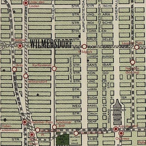 May include: A vintage map of a city with street names and red dots marking locations. The map is in a light green color with brown lines and text. The map shows the neighborhoods of Zehlendorf and Wilmersdorf.