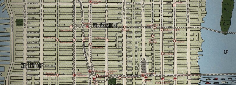 May include: A vintage map of a city with street names and red dots marking locations. The map is in a light green color with brown lines and text. The map shows the neighborhoods of Zehlendorf and Wilmersdorf.