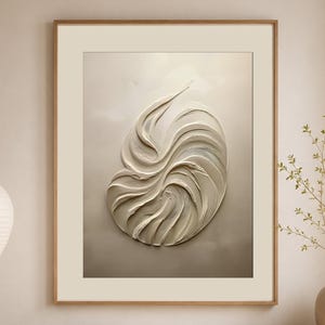Puede incluir: Una pieza de arte mural enmarcada que presenta un diseño abstracto de remolinos en color blanco roto texturizado sobre un fondo neutro. La obra se exhibe en un marco de madera clara y cuelga sobre una consola de madera en una habitación.