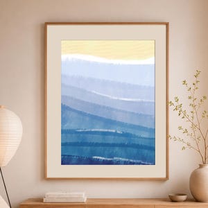 Puede incluir: Una impresión de arte mural enmarcada que presenta un paisaje abstracto con capas horizontales de color. La sección superior es de color amarillo pálido, que transiciona a múltiples tonos de azul, desde azul cielo claro hasta azul marino profundo.