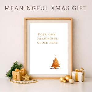Puede incluir: Una lámina enmarcada con el texto "YOUR OWN MEANINGFUL QUOTE HERE" en letras doradas sobre una ilustración de un árbol de Navidad dorado estilo acuarela. El marco es de madera clara, presentado con cajas de regalo y ramas de pino.