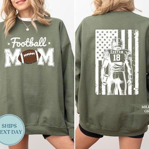 May include: Military green sweatshirt with "Football Mom" text and a football graphic on the front. The back features a football player graphic with an American flag design. The text "Custom 18" is on the back.