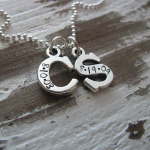 Peut inclure: Un collier en argent avec deux pendentifs, l'un avec la lettre "C" et la date "8.10.03" et l'autre avec la lettre "S" et la date "8.19.09".
