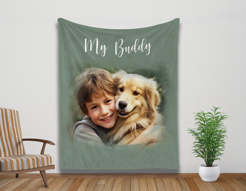 K&ouml;nnte beinhalten: Eine salbeigr&uuml;ne Decke mit den Worten "My Buddy" in wei&szlig;er Schrift. Die Decke zeigt ein Portr&auml;t eines Kindes, das einen Golden Retriever-Hund umarmt. Das Bild hat einen weichen, malerischen Effekt.