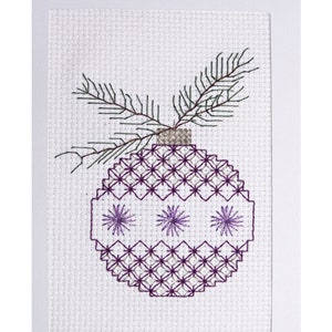 May include: A white cross-stitch pattern of a purple and white Christmas bauble with a green sprig on top. The text "Sugar Plum Ornament" is below the bauble.