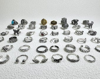 May include: A collection of 35 silver rings with various designs, including animal, geometric, and abstract patterns. Some rings feature gemstones.