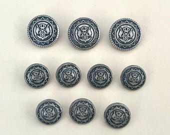 古びたシルバーの紋章ボタン：ヴィンテージの金属製盾ボタン