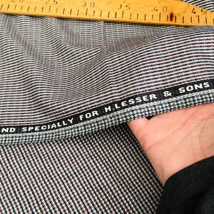 以下が含まれることがあります： グレーと白の模様の生地のクローズアップ。黒いラベルには「And Specially For H. Lesser & Sons」と書いてあります。