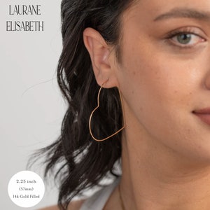 May include: A pair of gold-filled heart-shaped hoop earrings. The earrings are 2.25 inches (57mm) in diameter.