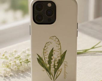 May include: A cream-colored smartphone case featuring a botanical illustration of green lily of the valley stems with white bell-shaped flowers and the name Charlotte printed in a cursive script font on the lower right side.