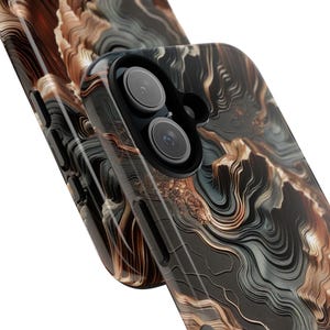 May include: Close-up of two phone cases with a swirling, abstract design in shades of black, brown, and gray. The cases feature a glossy finish and a camera lens cutout. The design resembles a marbled or layered effect.