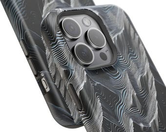Puede incluir: Primer plano de una funda de teléfono negra con un patrón topográfico en tonos grises y blancos. La funda tiene un recorte para la cámara con múltiples lentes y botones laterales. El diseño se asemeja a un mapa detallado.