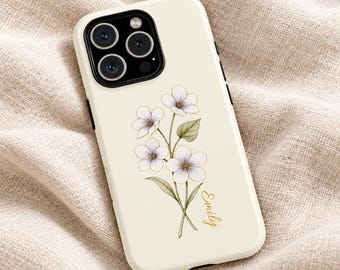 May include: A cream-colored smartphone case featuring a delicate illustration of a cluster of white flowers with green leaves and the name Emily written in elegant gold cursive script near the bottom of the floral design.
