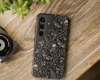 May include: A black smartphone case featuring a detailed white line art illustration of tangled vines, thorns, blackberries, ferns, thistles, moths, and human skulls. The design covers the entire back surface of the rectangular phone case.