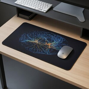 Może przedstawiać: Czarna prostokątna podkładka pod mysz z szczegółową, kolorową ilustracją mózgu. Ilustracja mózgu jest w odcieniach niebieskiego, żółtego i pomarańczowego. Srebrna mysz bezprzewodowa leży po prawej stronie.