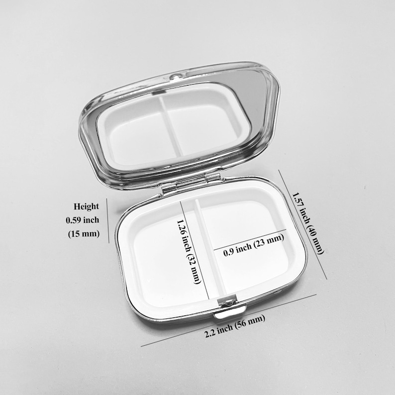 May include: A silver pill box with a mirrored lid. The box is divided into two compartments and measures 2.2 inches wide, 1.57 inches long, and 0.59 inches high.