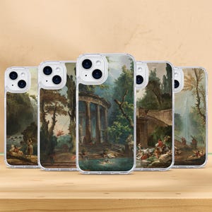 May include: A collection of clear phone cases featuring classical landscape paintings. Each case displays a different scene with waterfalls, classical architecture, and figures in a natural setting. The cases are displayed on a wooden surface.