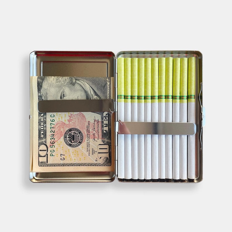 May include: A silver cigarette case with a $10 bill inside and a row of cigarettes with yellow filters.