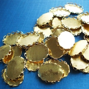 Puede incluir: Un mont&oacute;n de engastes ovalados de metal dorado con borde festoneado. Los engastes son para la elaboraci&oacute;n de joyas.
