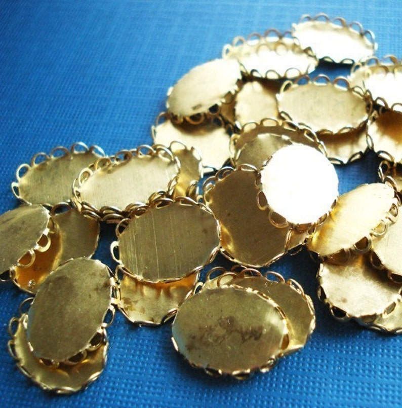 Puede incluir: Un mont&oacute;n de engastes ovalados de metal dorado con borde festoneado. Los engastes son para la elaboraci&oacute;n de joyas.