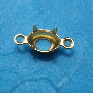 May include: Gold-toned metal setting with two loops on the sides and four prongs on the top, designed to hold a gemstone or cabochon.
