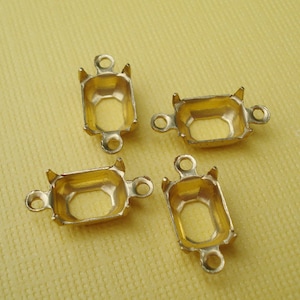 May include: Four gold-toned metal settings for bezel settings. Each setting has two loops on the side for attaching to a chain or other jewelry.