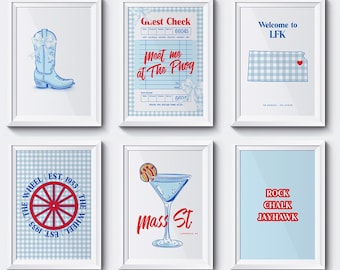 May include: Six framed art prints in white frames. The prints depict a cowboy boot, a guest check with "Meet me at The Phog", a Kansas map, a wheel design, a cocktail glass with "Mass St", and "Rock Chalk Jayhawk". The artist's name is "DESIGNSBYMX2".