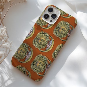May include: A phone case with a repeating pattern of suns and moons in a vintage style. The case is orange with a white border and has a camera cutout.