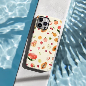 May include: A white phone case with a colorful fruit pattern. The case features a variety of fruits, including watermelon, papaya, cherries, peaches, and limes. The case also has a camera lens cutout and a white background.