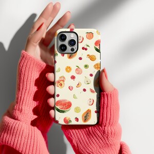 May include: A white phone case with a colorful fruit pattern. The case features a variety of fruits, including watermelon, cherries, peaches, and papaya. The case is designed for an iPhone.