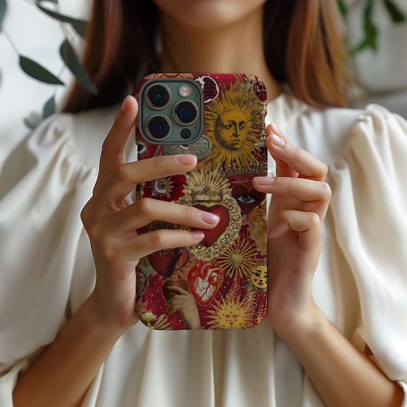 May include: A red, white and gold iPhone case featuring a collage of images including hearts, suns and eyes. The case has a vintage aesthetic.