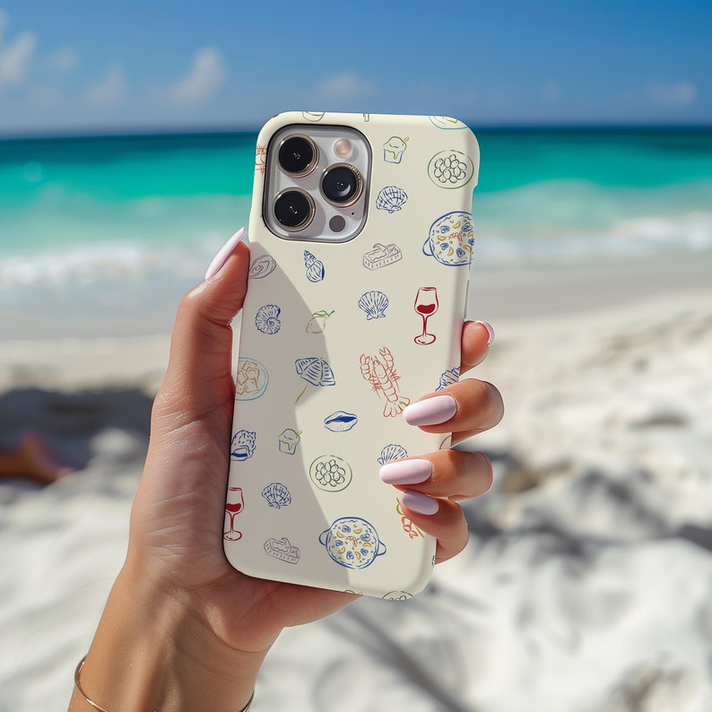 May include: A white iPhone case with a colorful design featuring various food items, including seafood, pasta, and wine glasses. The case has a camera lens cutout and a white background.