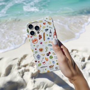 Puede incluir: Funda de tel&eacute;fono azul claro con un dise&ntilde;o de acuarela de alimentos y bebidas. El dise&ntilde;o incluye una langosta, una copa de vino, una baguette, queso y otros elementos culinarios. La funda se sostiene sobre un fondo de playa arenosa y oc&eacute;ano.