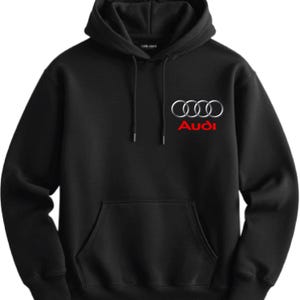 May include: Black hooded sweatshirt with a front pocket and drawstring hood. The Audi logo, featuring interlocking rings and the brand name in red, is displayed on the chest. A casual, comfortable garment.