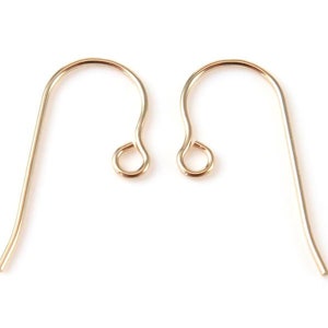 Puede incluir: Dos ganchos para pendientes de color dorado. Los ganchos son de metal y tienen un diseño simple y elegante.