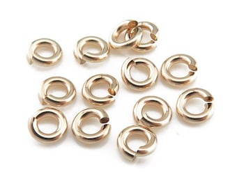 May include: A collection of 12 gold jump rings, each with a diameter of approximately 5mm. These rings are ideal for jewelry making and crafting projects.