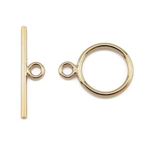 May include: Gold-toned metal toggle clasp with a round ring and a straight bar with two loops.