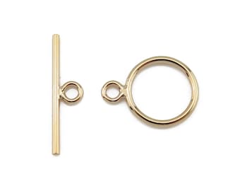May include: Gold-toned metal toggle clasp with a round ring and a straight bar with two loops.