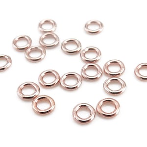 May include: A collection of 18 rose gold jump rings, ideal for jewellery making.