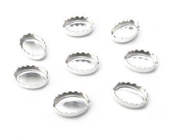 Puede incluir: Ocho ajustes de metal ovalados de plata con bordes festoneados.