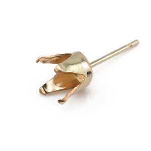 May include: Gold-toned earring setting with a prong setting for a stone. The setting is attached to a post with a small backing.