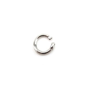 May include: Silver jump ring, a small circular metal ring with a gap, used for connecting jewellery components.