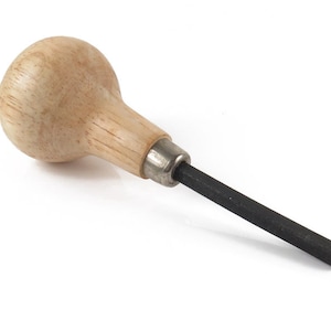 May include: A wooden handled metal tool with a black, rectangular tip. The tool is used for shaping metal.