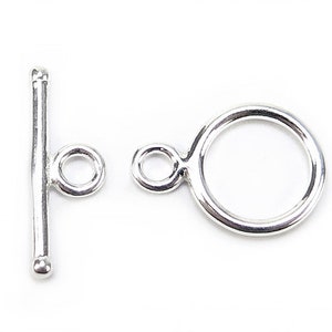 Può includere: Chiusura a scatto in argento con un anello rotondo e una barra con un piccolo anello. Questa chiusura è usata per la creazione di gioielli.