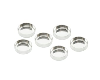May include: Six small, round, silver-coloured metal bezels are arranged on a white background. Each bezel has a shallow, concave interior. They are likely used for jewellery making or crafting projects.
