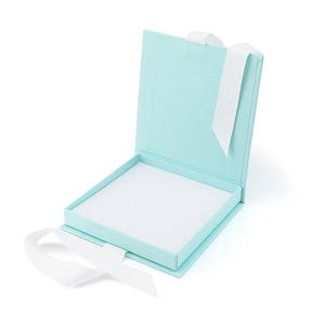May include: An open, light blue gift box with a white interior and a white ribbon. The box is square and has a hinged lid. The ribbon is tied in a bow on the front of the box.
