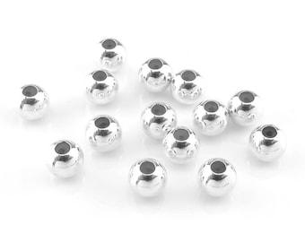 May include: A collection of 16 silver-toned round beads with a smooth, shiny finish. The beads have a small hole in the center for stringing.