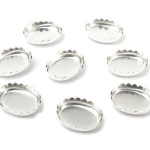 Puede incluir: Ocho bandejas de metal ovaladas de color plateado con bordes festoneados. Las bandejas están vacías y dispuestas en círculo sobre un fondo blanco.