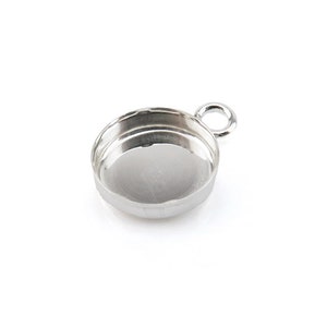 May include: Silver-toned pendant with a round bezel setting and a loop for attaching a chain or cord.